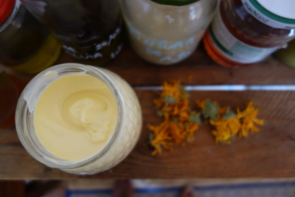 Jar of natural moisturiser with calendula flowers